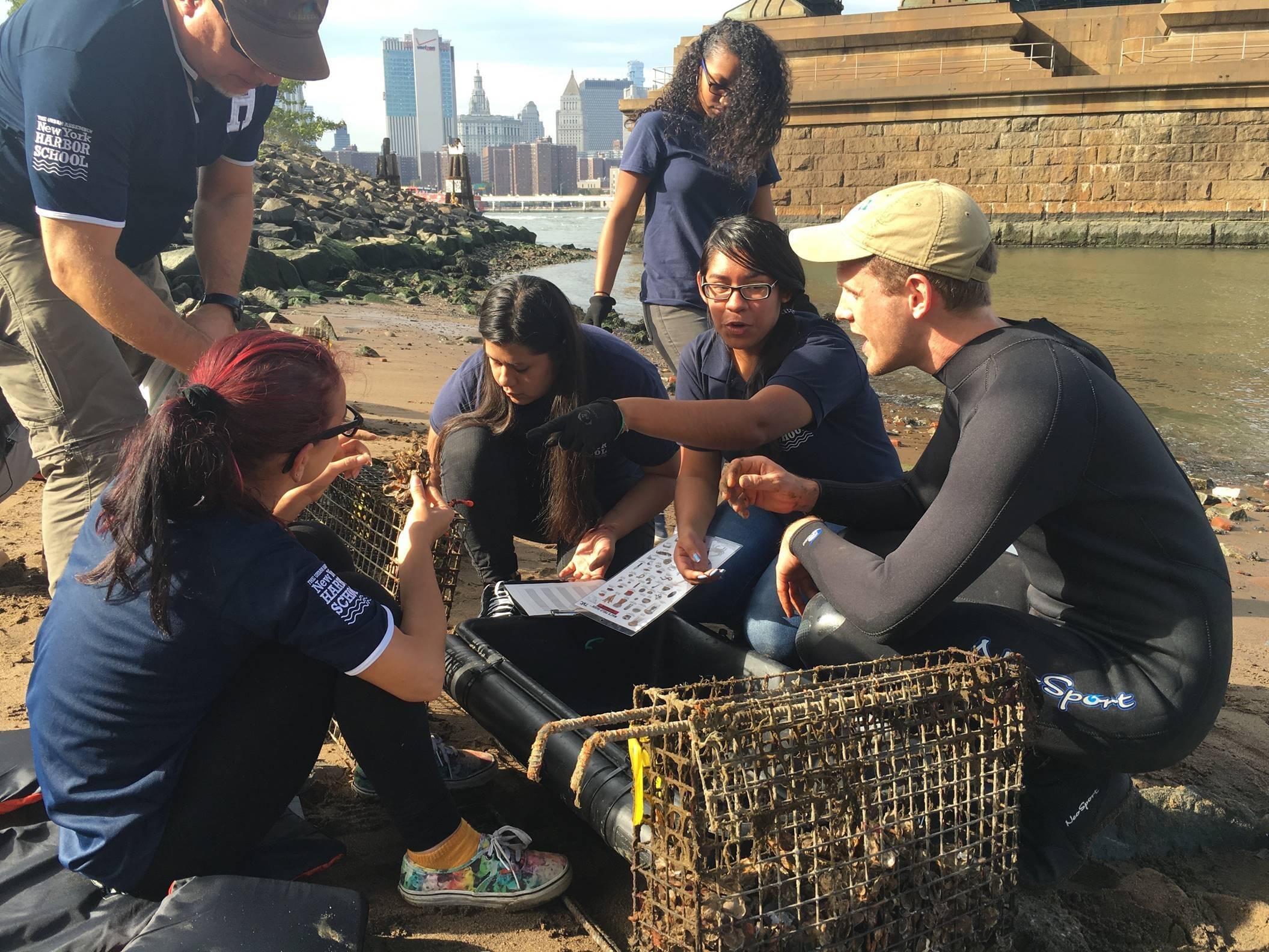 Students sitting in the bay learning about oysters.