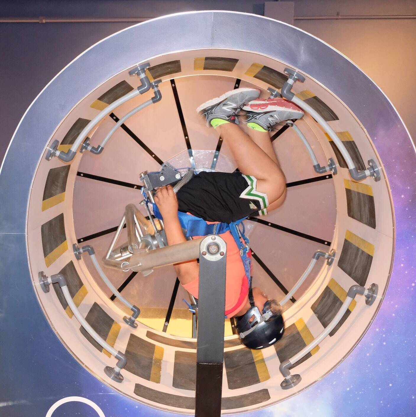 Student spinning upside down in a science center.